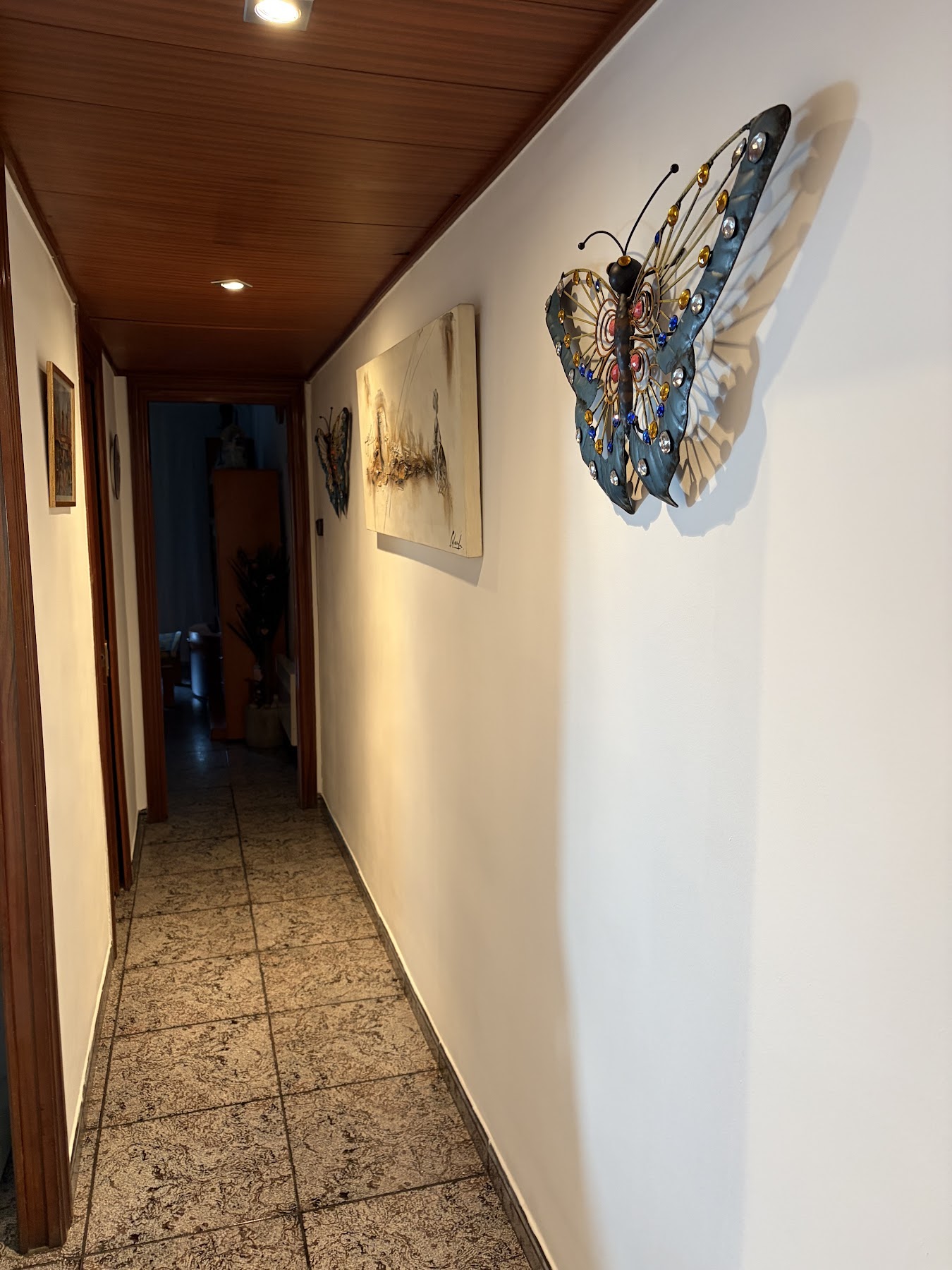 Pasillo pintado y cuadros colgados
